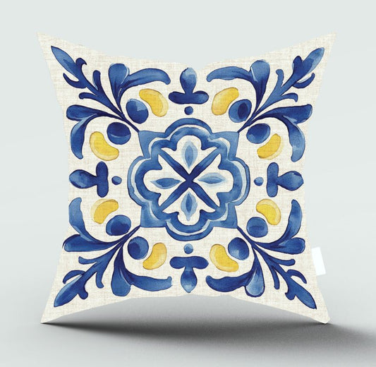 A square decorative throw pillow with a white linen-textured background and a traditional Portuguese tile-inspired pattern in blue and yellow, shown on a light gray background.