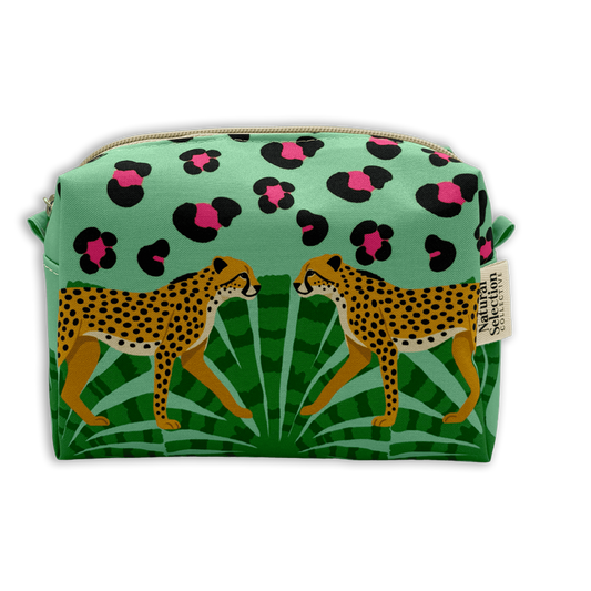 A rectangular zippered cosmetic pouch featuring a tropical print with two cheetahs walking among green palm leaves, and a mint green top section with black and pink leopard spots. A small fabric tag on the right side reads 'African American'.