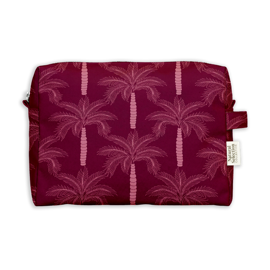 Aswan Palm Toiletry Bag featuring pink palm trees on deep burgundy