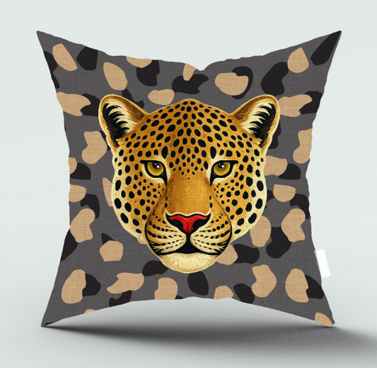 A square throw pillow featuring a detailed graphic of a leopard's face in the center, set against a dark gray background with beige and black leopard spots.