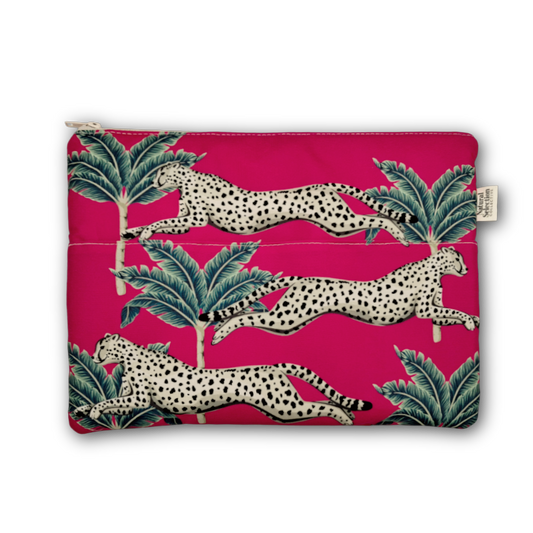 A zippered pouch featuring a vibrant magenta pink background with a repeating pattern of leaping spotted cats and green palm leaves. A small fabric brand tag is visible on the right side.
