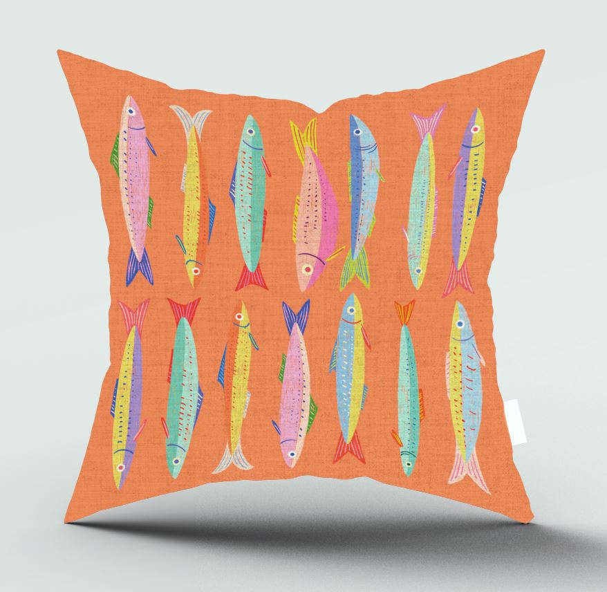 An orange throw pillow featuring a colorful pattern of illustrated fish in pink, yellow, blue, and green, shown against a neutral light gray background.