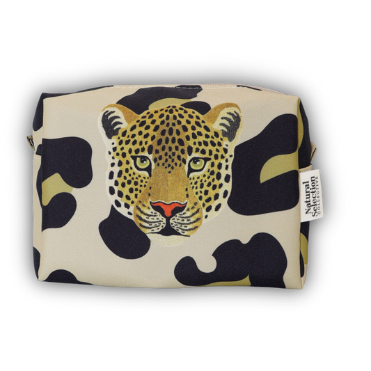 A rectangular zip pouch featuring a leopard face illustration over a black and beige camouflage pattern, with a small side tag reading Natural Living Apparel.
