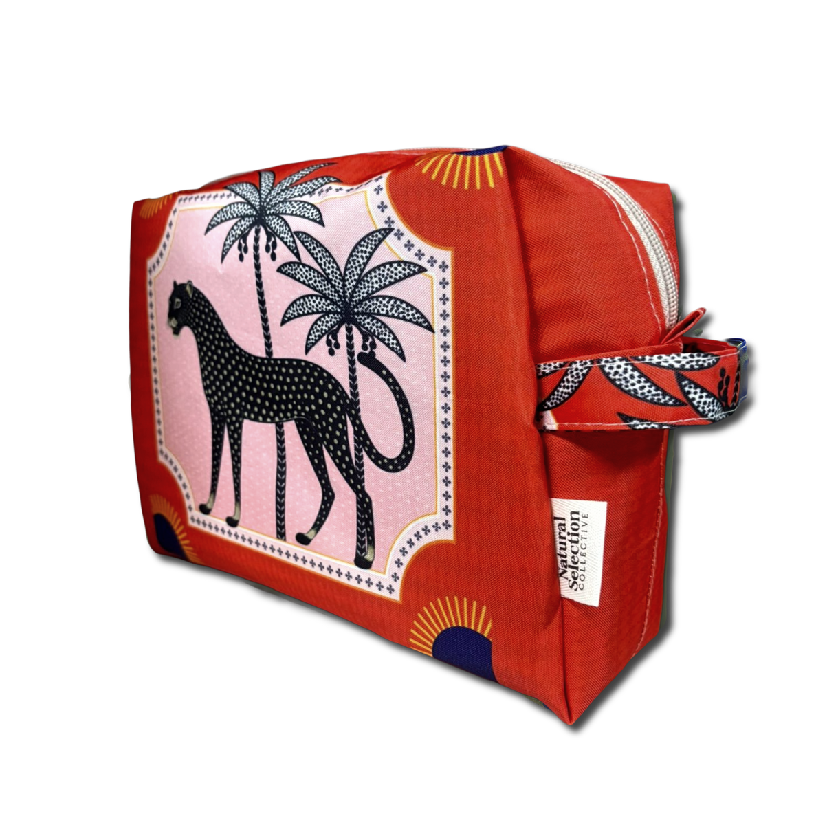 A red zippered cosmetic pouch featuring a pink panel with a black leopard and palm tree print, a side loop with a matching print, and a white tag reading Natural Selection.