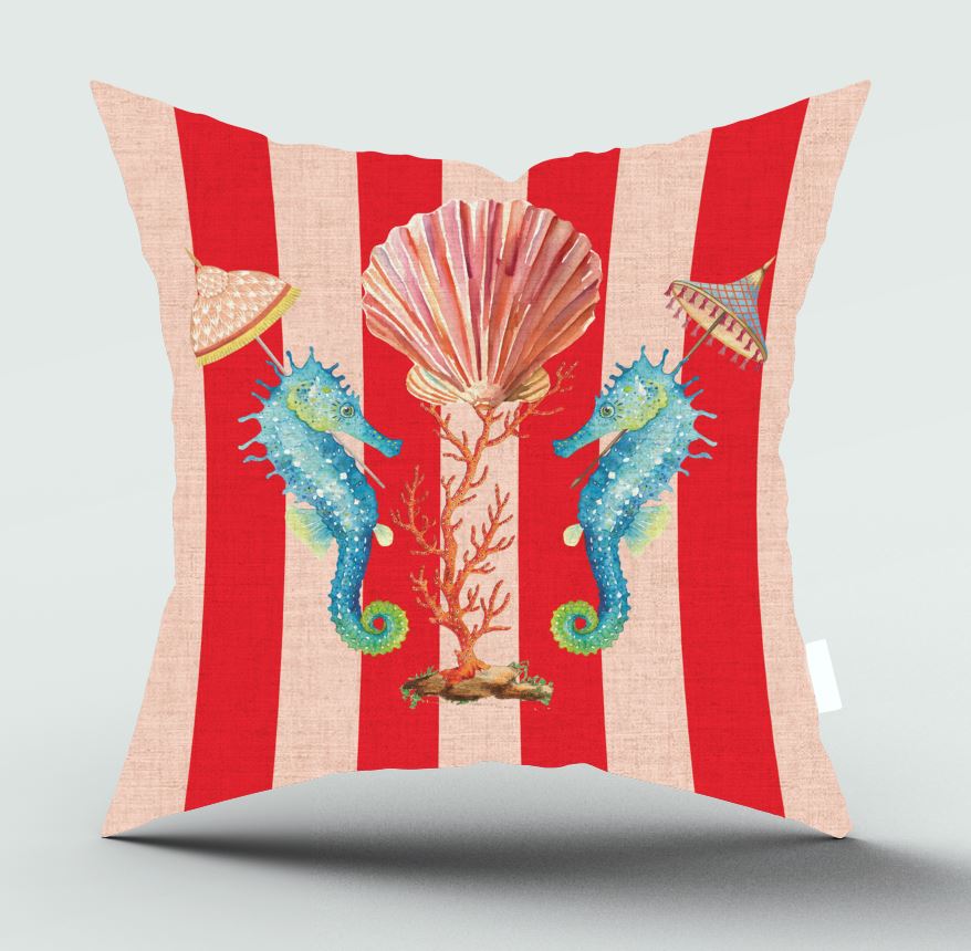 A square throw pillow featuring a vibrant red and beige striped background with a central underwater theme illustration of two blue seahorses, a pink seashell, coral, and small parasols, shown on a light gray background.