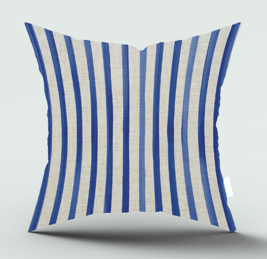 A square throw pillow with vertical stripes in royal blue and a warm off-white linen-like fabric, shown against a neutral light gray background with a soft shadow underneath.