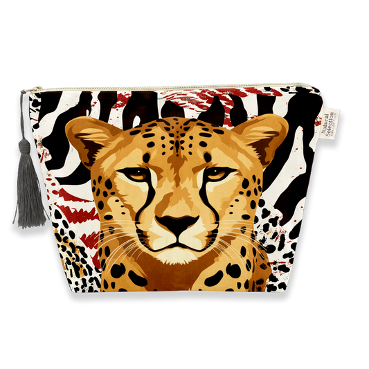 A zippered cosmetic pouch featuring a graphic print of a cheetah face over a black and white zebra pattern with red paint splatter accents, complete with a gray tassel on the left side.