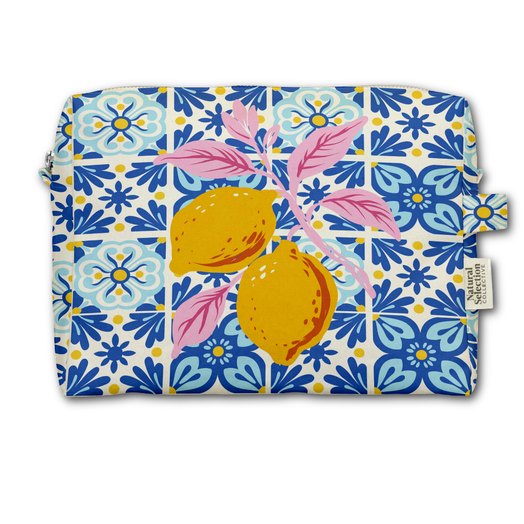 A rectangular zippered pouch featuring a colorful print of two yellow lemons on a pink branch over a blue and white tiled pattern background. A small fabric tag on the right side reads 'Natural Collections'.