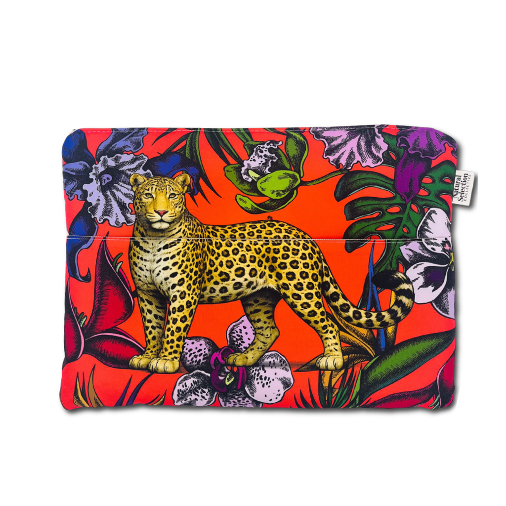 A laptop sleeve featuring a vibrant tropical print with a central leopard illustration, set against a bright red background with purple flowers and green leaves. A small white brand tag is visible on the right side.