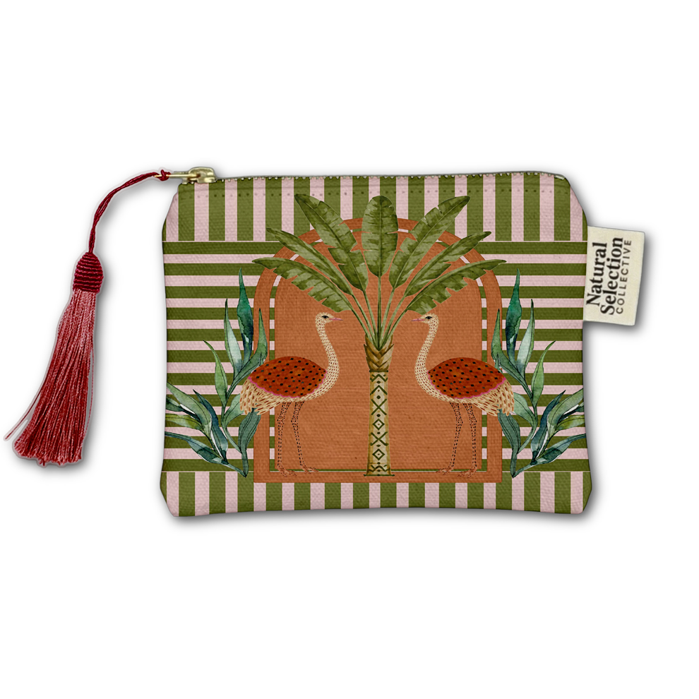 A rectangular zip pouch with a red tassel and a fabric label reading 'Natural Selection Collective' by Kiki Smith. The pouch features a tropical design with two flamingos, a palm tree, and striped green and beige borders.