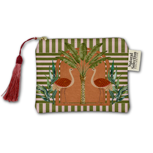 A rectangular zip pouch with a red tassel and a fabric label reading 'Natural Selection Collective' by Kiki Smith. The pouch features a tropical design with two flamingos, a palm tree, and striped green and beige borders.
