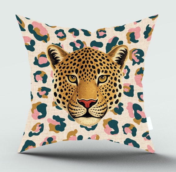 Square throw pillow featuring a detailed graphic of a leopard's face centered on a beige leopard-print background with pink, teal, and brown spots, shown against a light gray studio background.