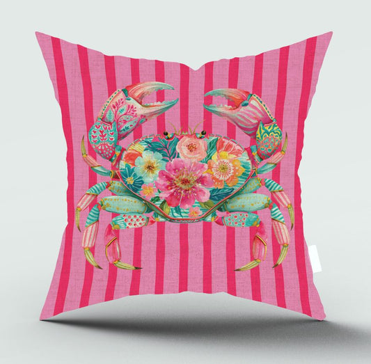 A square throw pillow featuring a vibrant, multicolored floral crab design on a bright pink and magenta striped background, set against a light gray studio backdrop.