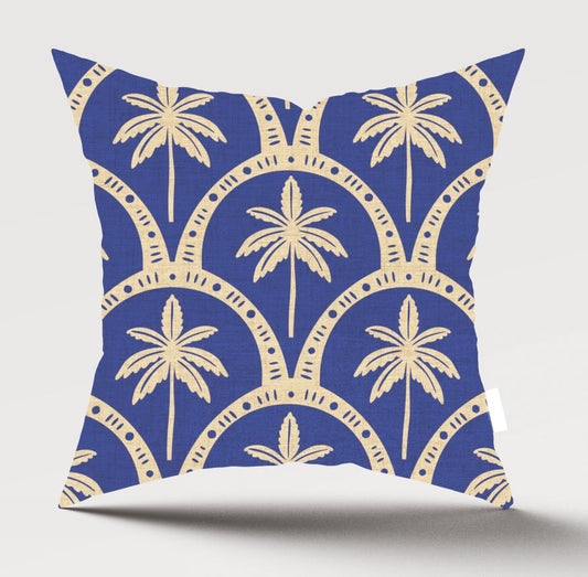 A square throw pillow featuring a navy blue and beige palm tree pattern, shown against a light gray background with a soft shadow underneath.