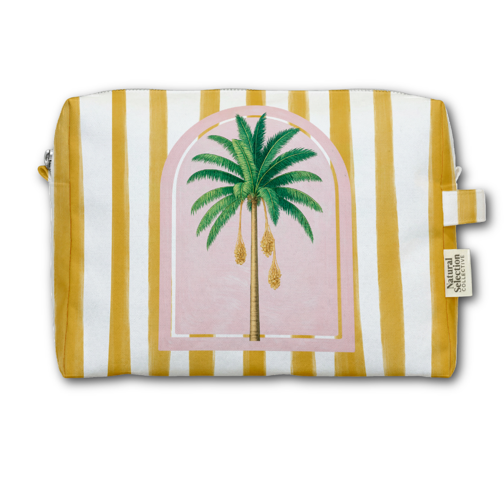 A rectangular zip pouch with a yellow and white vertical stripe pattern, featuring a central illustration of a green palm tree inside a pink arched frame. A small fabric brand tag is visible on the right side.