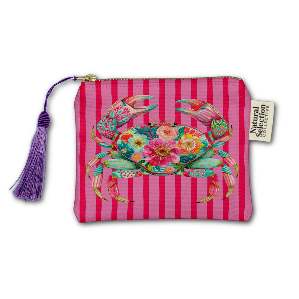 A zippered pouch with a pink and magenta striped background, featuring a colorful tropical crab and floral design on the front. The pouch has a purple tassel zipper pull and a side tag reading 'Natural Secretions'.