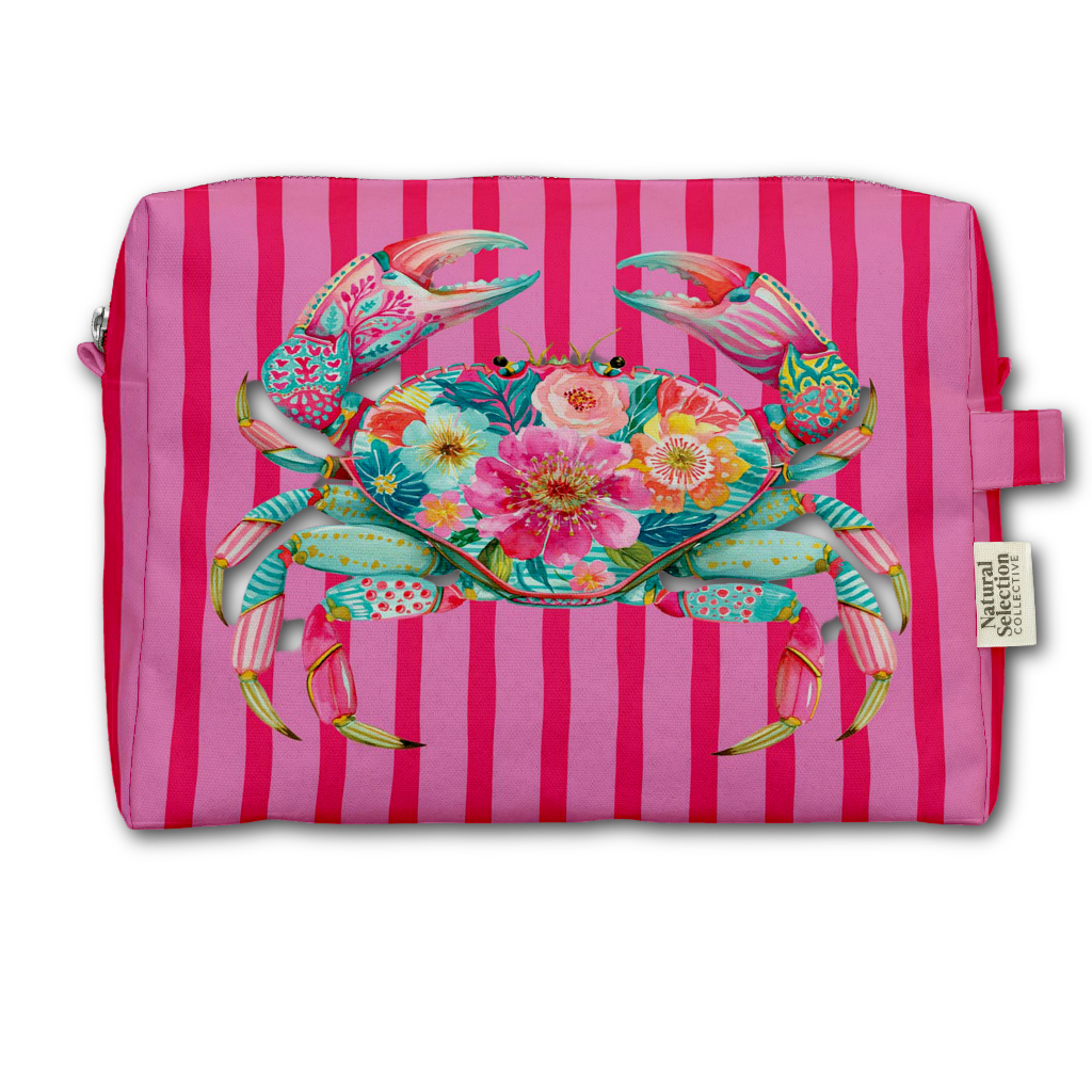 A rectangular zippered pouch with a pink and magenta vertical stripe pattern, featuring a large colorful floral crab graphic on the front. A small fabric tag on the right side reads Natural Living.
