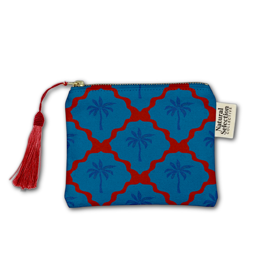 A zippered pouch featuring a blue and red geometric trellis pattern with palm tree motifs, a red tassel zipper pull, and a white brand tag reading 'Natural Selection'.