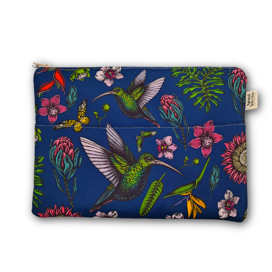 A zippered pouch featuring a vibrant tropical print with green hummingbirds, pink flowers, and green leaves on a deep blue background, shown against a plain white studio backdrop.