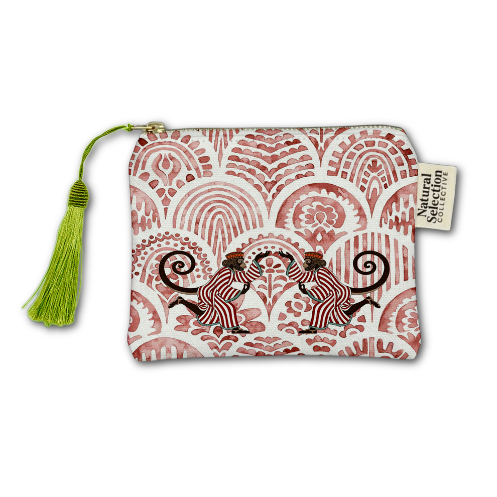 A small zip pouch with a white background and a dusty red hand-painted style pattern of two monkeys, featuring a bright green tassel on the left and a 'Soulful Collective' brand tag on the right.