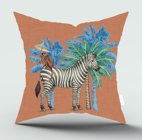 A square decorative throw pillow with a terracotta orange linen-textured background, featuring a whimsical illustration of a zebra, blue palm trees, and a monkey riding a bicycle.