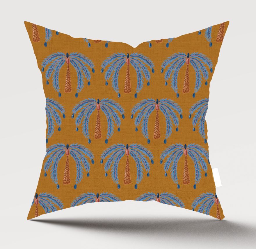 A square throw pillow featuring a repeating palm tree pattern on a mustard yellow background, with blue fronds and orange trunks, shown against a light gray studio background.