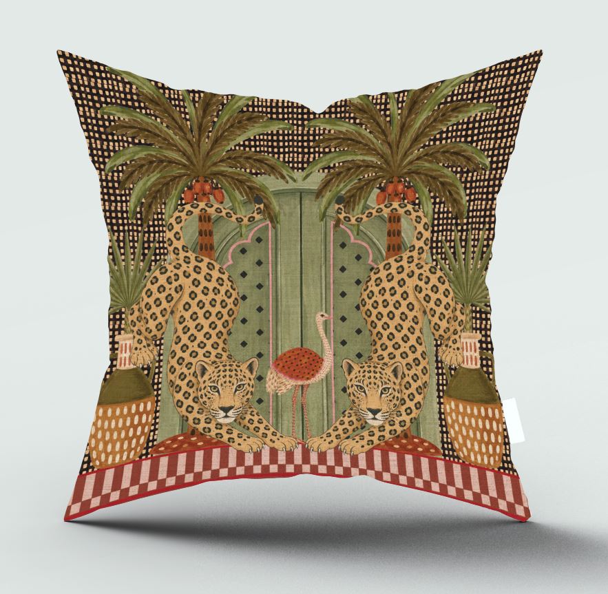 A square decorative throw pillow featuring a detailed vintage-style illustration of two leopards, two palm trees, and a central green door, with a red and white checkered border at the bottom, shown against a light gray background.