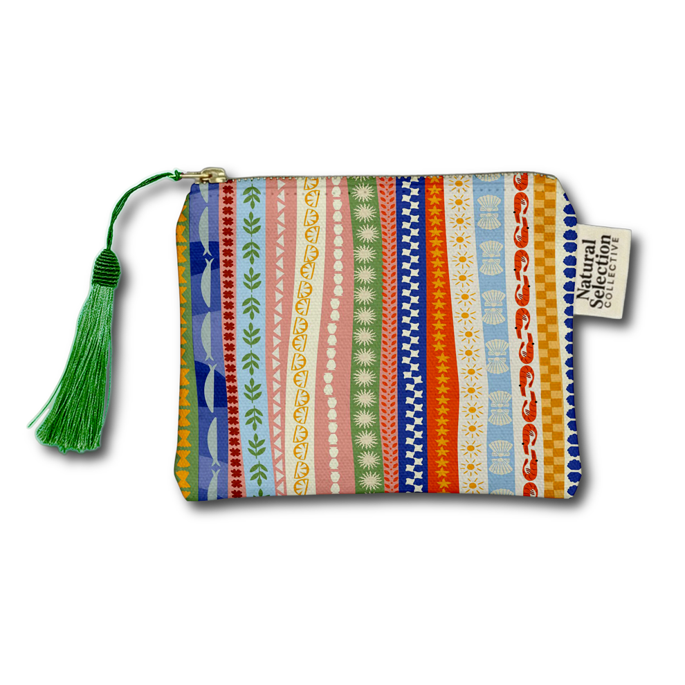 A rectangular zippered pouch with a colorful vertical stripe pattern featuring various geometric and floral motifs in blue, green, pink, orange, and yellow. It has a green tassel zipper pull and a white fabric brand tag that reads 'Natural Selection Co.