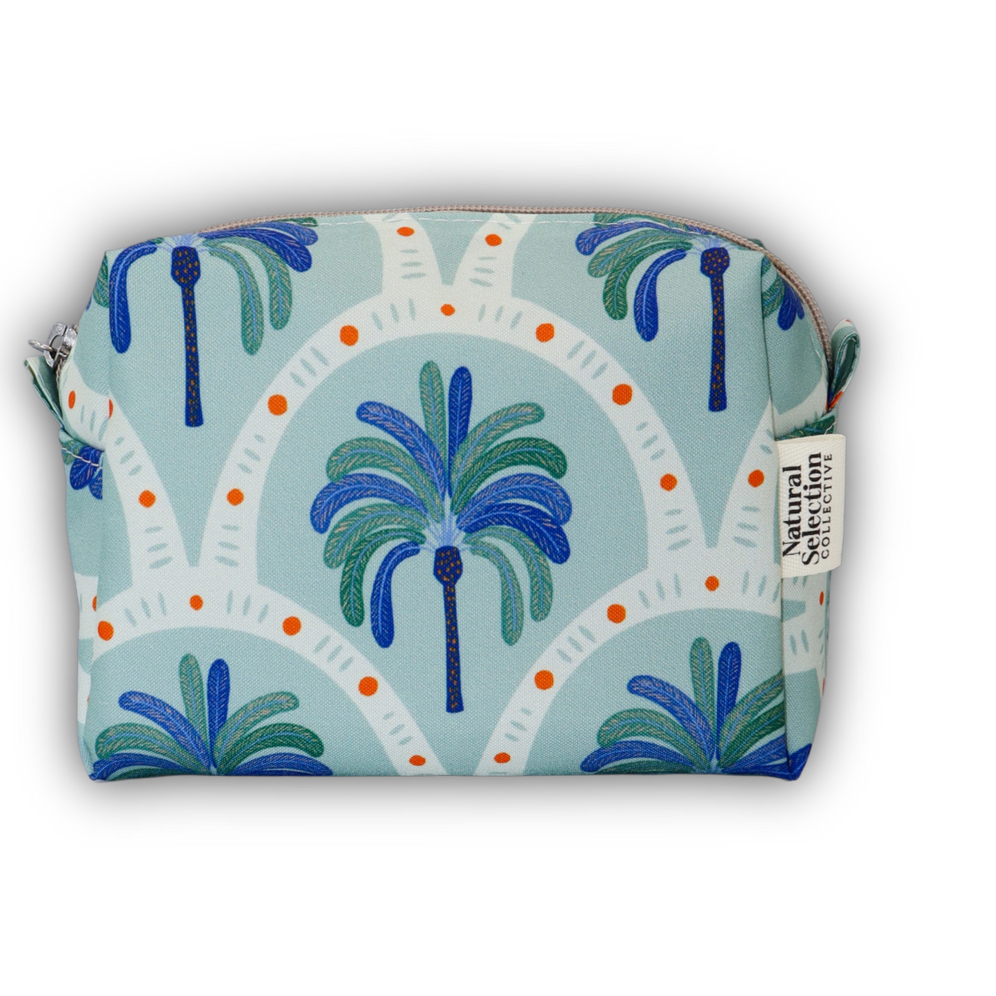A zippered cosmetic pouch featuring a tropical palm tree pattern in shades of blue and green on a light blue background, with white arched motifs and small orange dots. A side tag reads 'Natural Selection Co'.