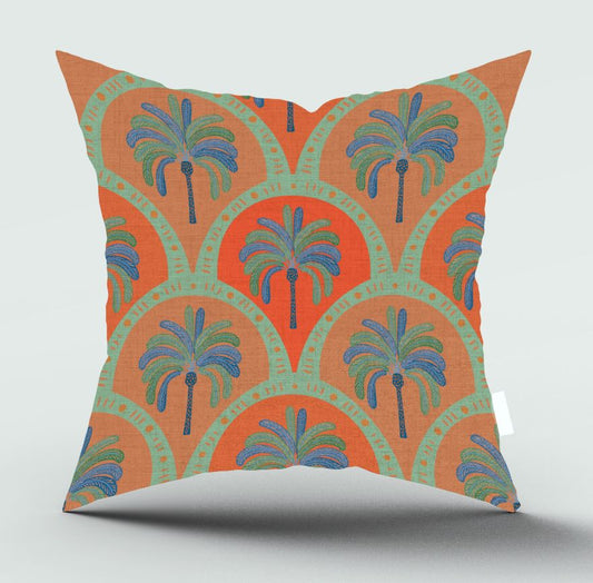 A square throw pillow featuring a retro bohemian pattern with orange and mint green semicircles, blue palm trees, and turquoise script text, shown on a light gray background.