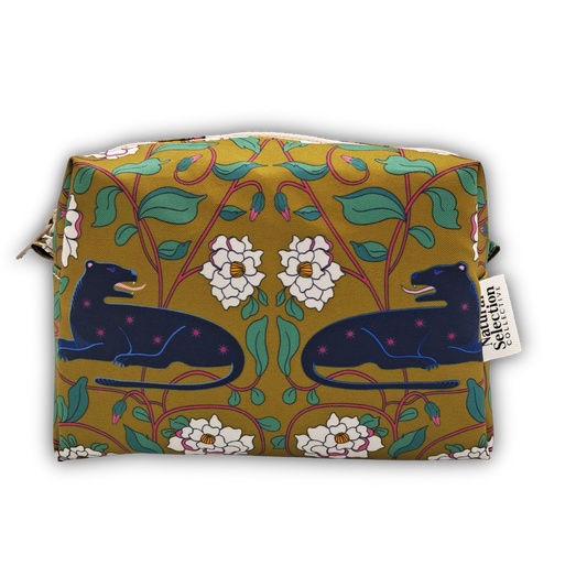 A rectangular cosmetic pouch featuring a William Morris-inspired floral pattern in mustard yellow, green, white, and navy blue, with two dark blue panthers. A white fabric tag on the right side reads 'Natchez Collection'.