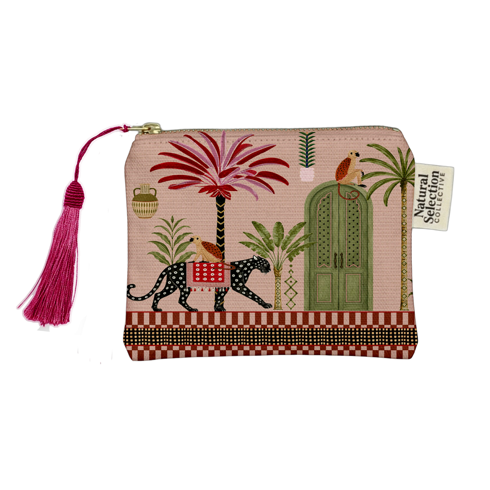A rectangular zip pouch with a pink tropical print featuring palm trees, a green door, a spotted leopard, birds, and a bright pink tassel zipper pull. A fabric tag reads 'Natural Color Collection'.