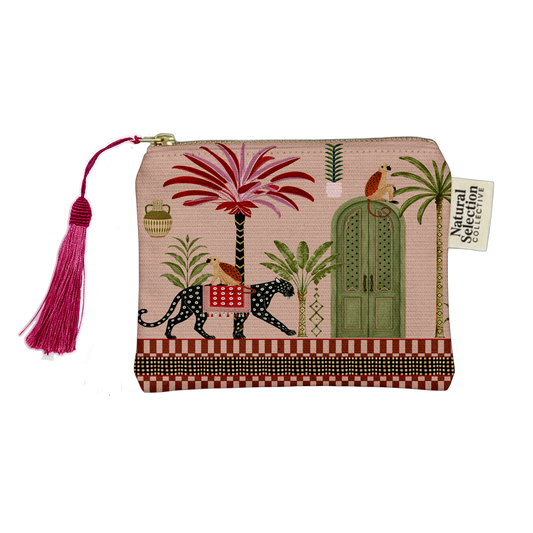 A rectangular zip pouch with a pink tropical print featuring palm trees, a green door, a spotted leopard, birds, and a bright pink tassel zipper pull. A fabric tag reads 'Natural Color Collection'.