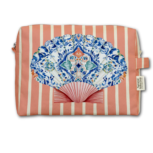 A rectangular cosmetic pouch with coral pink and cream vertical stripes, featuring a large printed folding fan design in blue, white, and orange on the front, with a small fabric brand tag reading Natural Living on the right side.