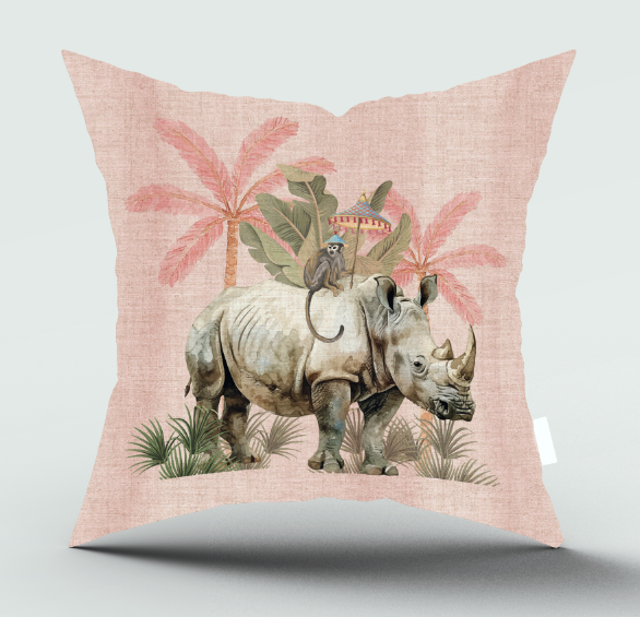 A square throw pillow with a light pink linen-textured background featuring a whimsical safari illustration of a rhinoceros, a monkey on a small pedestal, and palm trees, shown against a neutral light gray background.