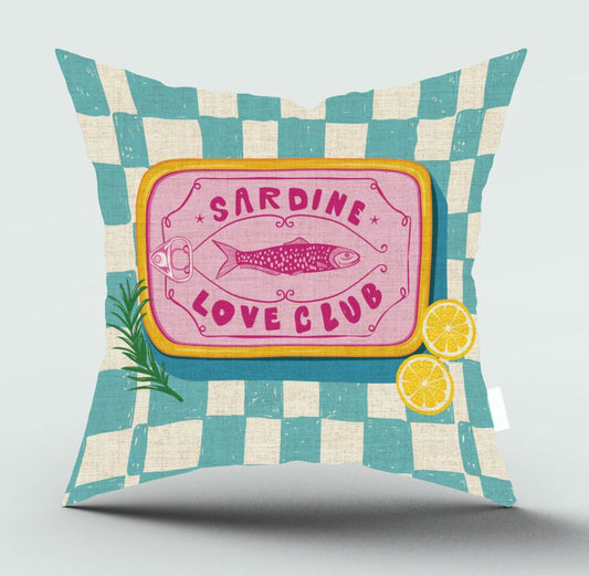 A square decorative throw pillow with a teal and cream checkered pattern, featuring a central pink label with a fish illustration and the words 'SARDINE LOVE CLUB', plus small lemon and herb graphics, shown on a light gray background.