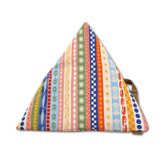 A triangular floor cushion with a vibrant, multicolored vertical stripe pattern featuring various retro motifs like stars, flowers, stripes, and waves in pink, blue, green, orange, and yellow. A brown wooden support leg is visible on the right side, set against a plain white background.