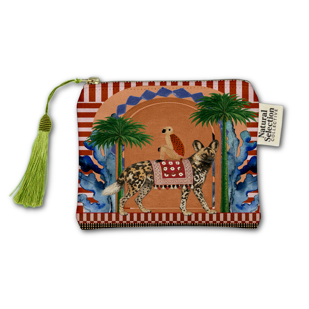 A square zippered pouch featuring a colorful, hand-painted style illustration of an African wild dog with a bird on its back, flanked by palm trees. The pouch has a red and white striped border, a green tassel zipper pull, and a white fabric brand tag reading 'Natural Secret Society'.